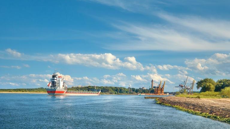 Large container cargo ship entering port in Swinoujscie, Poland, on a bright sunny day with blue sky and feather clouds shutterstock_1535164799.jpg