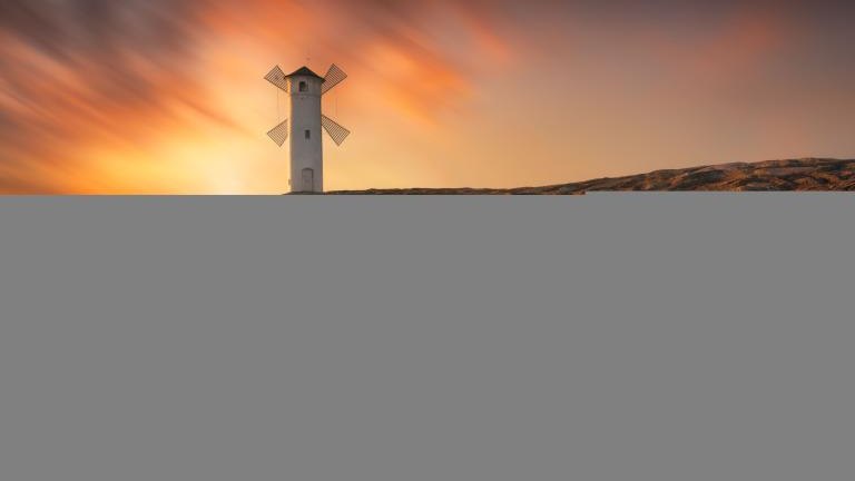 Pond Mlyny - a windmill pond by the sea in Swinoujscie, Poland. A white mill by the sea with a beautiful sunset. Sea sunset landscape. shutterstock_2166731681.jpg